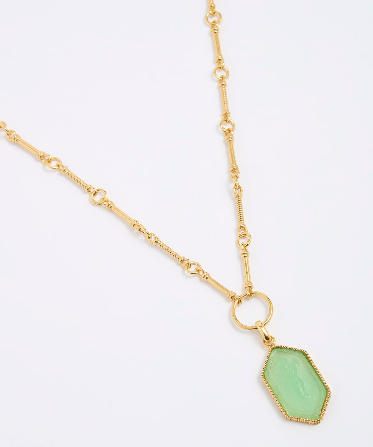Gold coloured necklace with a green pendant on a white background
