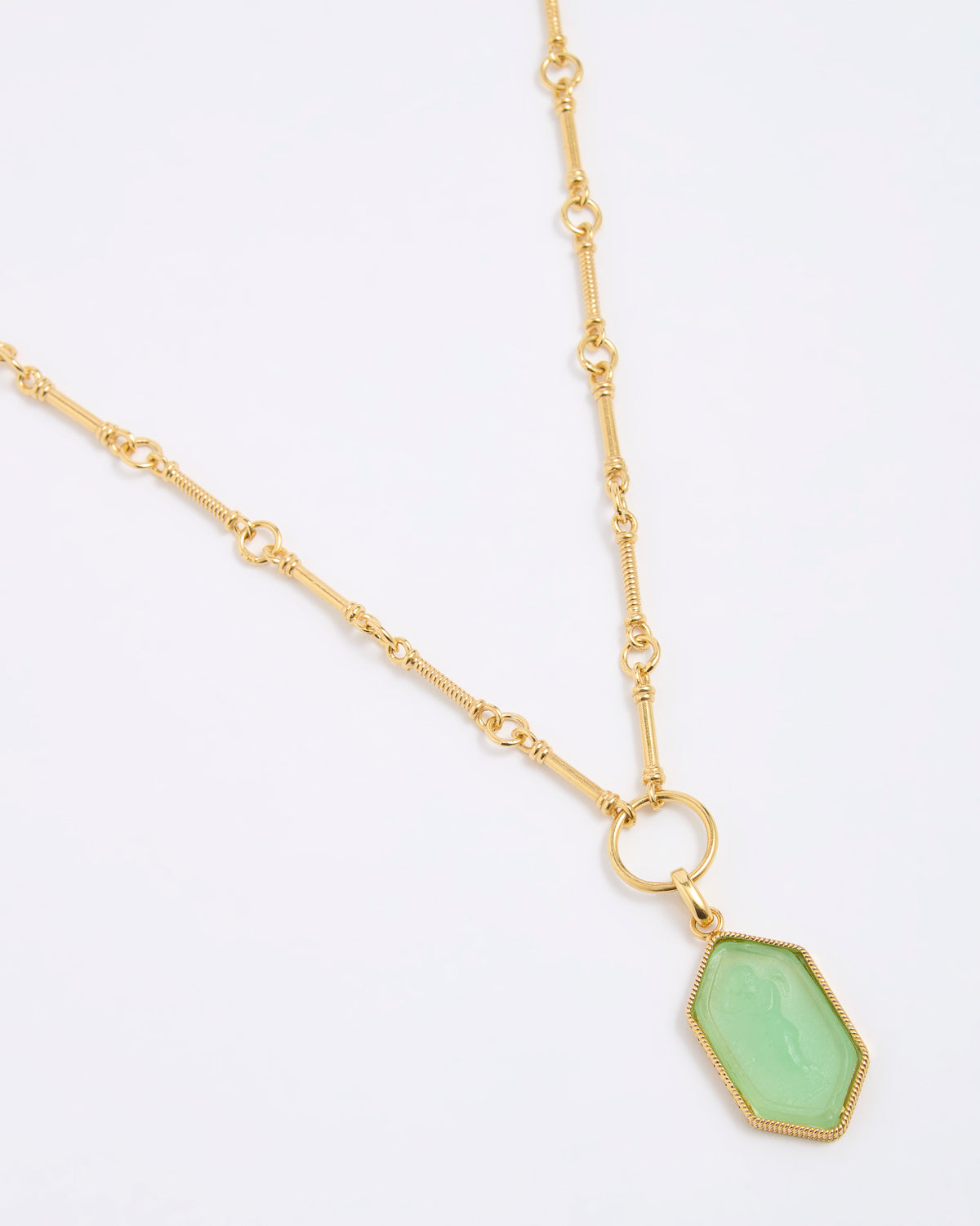 Gold coloured necklace with a green pendant on a white background