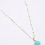 Necklace with a turquoise shell pendant on a white background