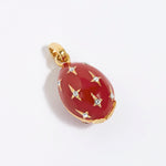 Red egg-shaped pendant with gold accents and star designs on a white background