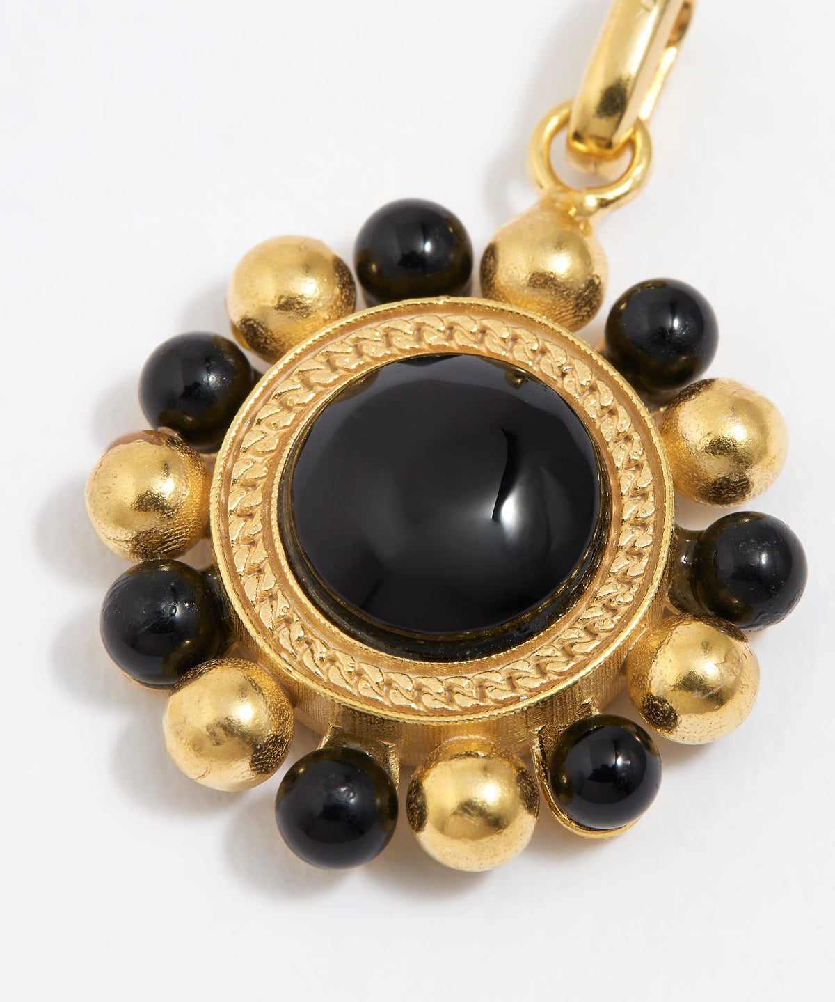close up image of Gold circular charm pendant with central onyx stone with black and gold beaded edge,  on a white background