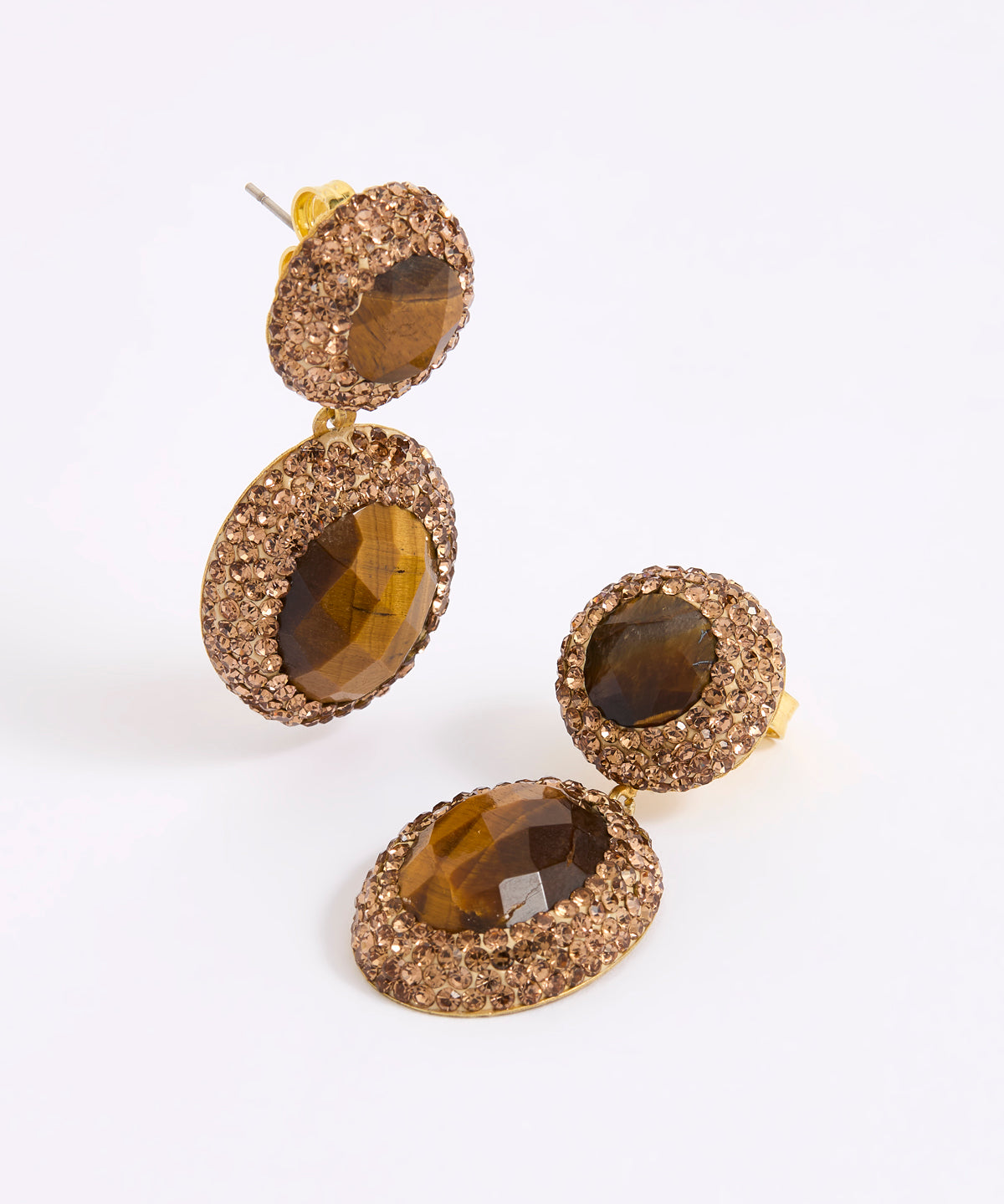 A pair of gold-toned drop earrings with oval faceted brown gemstones surrounded by textured crystal-like detailing, shown on a clean white background.