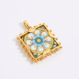 Gold square pendant with a floral tile design on a white background