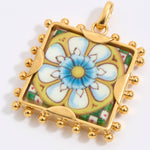 Gold square pendant with a floral tile design on a white background