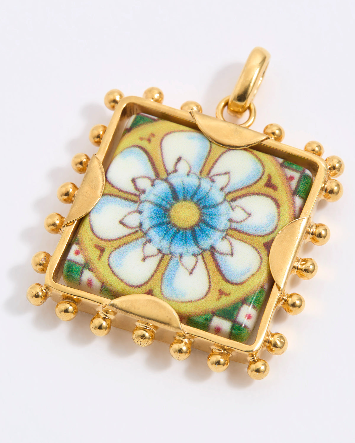 Gold square pendant with a floral tile design on a white background