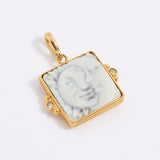 Gold-framed square pendant with a face of a sun and moon design set on a square tile on a white background