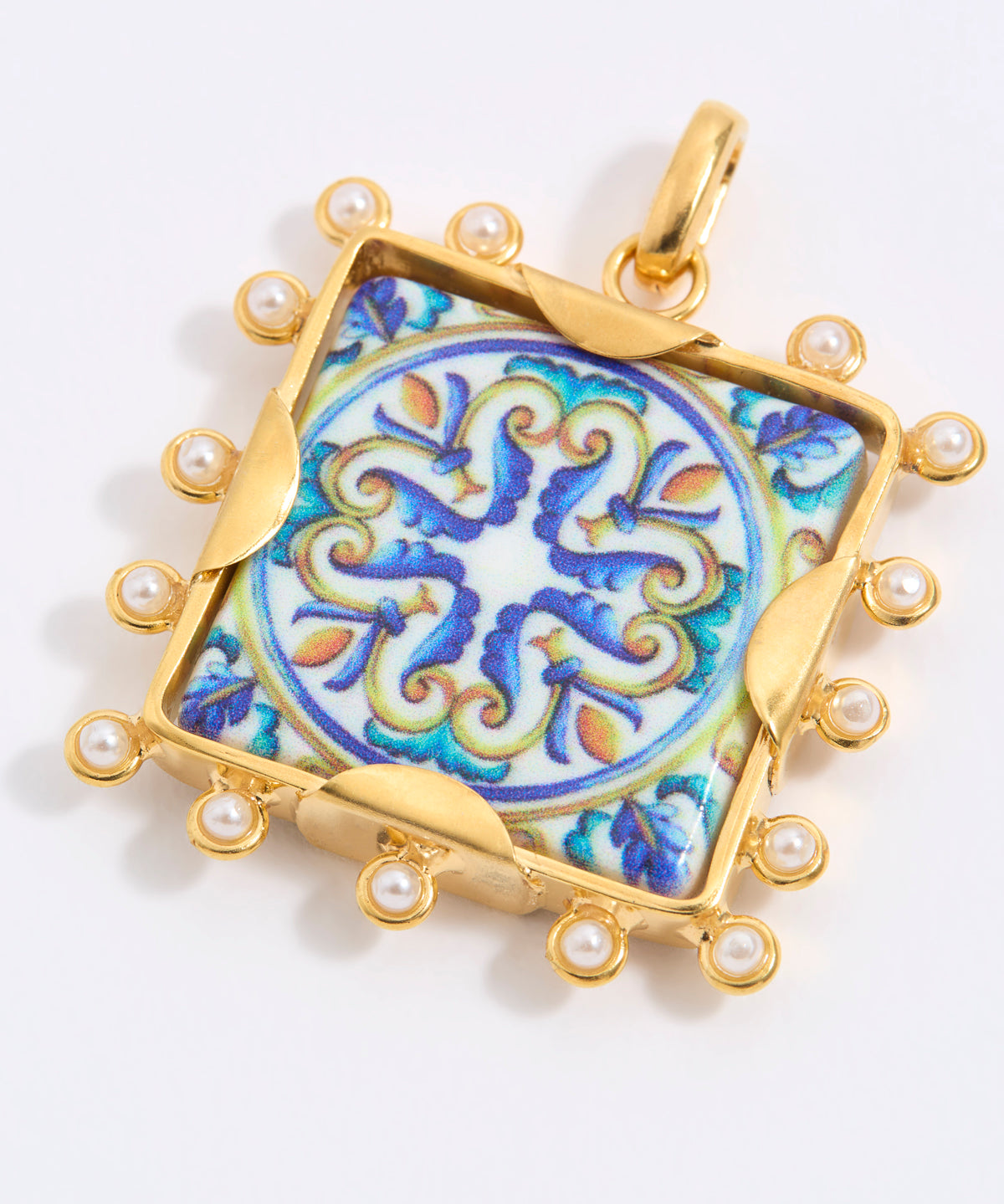 Decorative pendant with blue and gold design on a square tile with mini pearl edging  on a white background