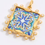 Decorative pendant with blue and gold design on a square tile with mini pearl edging  on a white background