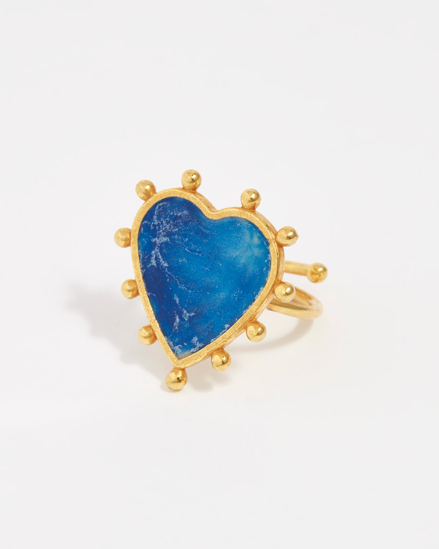 product shot of blue tonal enamel in a heart shaped ring with gold beads on the outside 