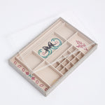 Clear perspex lid on top of the embroidered linen Kinship Press X Soru Treasures Jewellery Tray