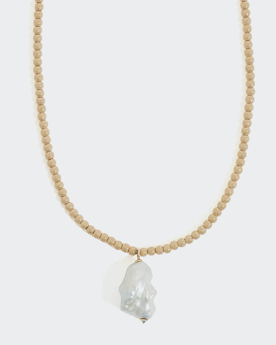 soru gold beaded necklace with a large baroque pearl pendant, made in 24ct gold plated silver