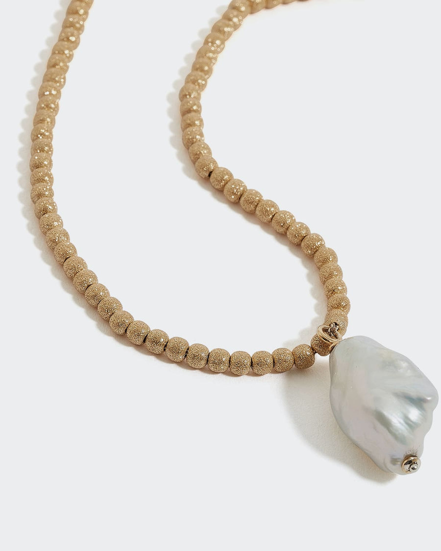 soru gold beaded necklace with a large baroque pearl pendant, made in 24ct gold plated silver